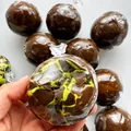Detaillierte Makroansicht von grünem Matcha und dunklem Schokoladenwachs-Spielzeug - Matcha Knuspriger Ball / Matcha-Grün