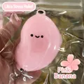 Close-up of pink cute banana squishy stress relief toy in plastic packaging bag - Simulated Banana Pink