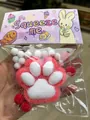 Detailansicht des 7 cm großen Katzenpfoten-Squishy-Spielzeugs in der Verpackung - Großer Beflockter Stil / Rote Katzenpfote