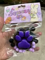Lila und schwarzes Katzenpfoten-Quetschspielzeug, 7 cm groß, ideal zum Stressabbau und Spiel. - Schwarz-weiße Katzenpfoten-leuchttafel