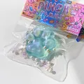 Detailaufnahme eines hellblauen Katzenpfoten-Squishy-Spielzeugs mit Glitzer und Perlen - Kristall Katzenpfote / Funkelndes Grüngold