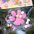 Primo piano di un giocattolo squishy a zampa di gatto rosa in una confezione carina - Zampa di Gatto in Cristallo Rosa / Rosa