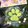 Detail view of a cute lime green paw squishy toy with colorful glitter and sequins inside packaging. - Fluorescent Crystal Cat Paw / Fluorescent Colors