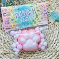 Close-up of pink flocked cat paw squishy toy in colorful Pinch Family packaging - Plush Cat Paw Pink