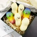 Nahaufnahme von bunten Regenbogen-PU-Erdnuss-Squishies mit Gesichtern in einer Geschenkbox - Gute Dinge passieren / bunt