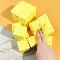 Dettaglio ravvicinato di una mano che preme un giocattolo squishy a forma di formaggio - Blocco di Formaggio (Piccolo) / 5cm / Giallo