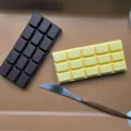 Close-up of brown and yellow chocolate-shaped slow rebound squishy toys for stress relief. - Chocolate Bar / Yellow