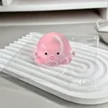 Detailansicht des süßen rosa durchscheinenden Oktopus-Squishy-Spielzeugs auf einem Tablett - Rosa