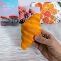 Realistic croissant squishy toy held in hand for stress relief and fun decoration. - Mini Croissant