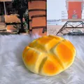 High-detail macro view of a soft slow-rising pineapple bun squishy toy on white fur - Large Pineapple Bun / Orange