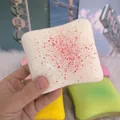 Detailed macro view of the red speckled texture on a white cheese toast squishy toy - Cream Toast