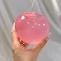 Detail of a pink translucent apple-shaped slow rebound squishy toy held in hand - Pink Apple