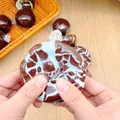 Close-up van een handgemaakte zachte stressbal met een chocolade krakende textuur - Zeezout Krokante Bal