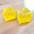 Nahaufnahme von zwei gelben Käse-Quetschspielzeugen mit realistischen Texturen - 4,5cm Maltose Käse / Honigfarbe