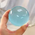 Close-up view of a high-transparency blue spherical squishy toy held in a person hand - 6cm Size / Mint Blue