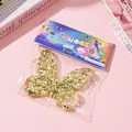 Butterfly-shaped gold sequin squeeze toy inside rainbow themed retail packaging bag - Gold Butterfly
