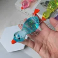 Creative blue translucent duck squeeze toy with glitter filling shown in hand - Duck Shape / Blue