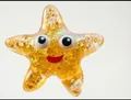 Cute starfish-shaped squishy stress relief toy with golden glitter and cartoon face - Starfish Shape / Orange