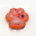 Cute orange cat paw squishy toy with colorful glitter flakes for stress relief. - Colored Orange