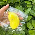 Cute yellow banana squishy toy with a smiley face in clear plastic packaging for stress relief - Large Banana Shape / Yellow