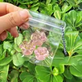Detail view of three pink translucent cat paw squishy toys inside a clear bag - Set of 3 / Pink