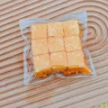 Vue détaillée de 9 jouets squishy cubes de lait de coco dans un sac pour soulager le stress. - Style Cube Frit / Orange