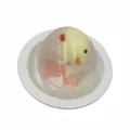 Simpatico giocattolo antistress a forma di uovo di pulcino giallo su piatto bianco - pulcino