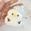 Gedetailleerde close-up van een schattige witte sneeuwpop squishy in een zakje - Sneeuwpop met blauwe hoed / Blauw
