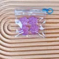 Close-up of four translucent purple cat paw squishy toys stored in a clear zipper bag. - Set of 4 / Purple