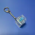 Transparent mechanical switch keychain fidget toy with blue stem on a blue background - With LED Lights / 1-Key Transparent