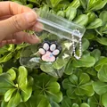 Cute mini cat paw squishy toy in clear packaging with purple bead chain for stress relief - Black and Pink Paw Accessory
