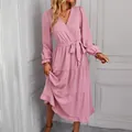 Detailed view of a pink V-neck long sleeve tiered midi dress with a waist tie. - S / Pink