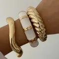 Stack of chunky gold tone and white acrylic cuff bracelets with irregular wavy textures - Streamline Wave Pleated Bangle Set (6649501HB) / Three-Piece Set / Gold And White