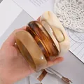 Set of chunky acrylic bangles featuring tortoiseshell and marbled patterns on hand - Minimalist Thick Bangle Set (6754401) / Three-Piece Set / Light Brown Dark Brown Cream Combo