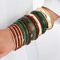 Stunning set of multi-color acrylic and polished gold-tone metal bangles on arm - 6109533416065 / Vintage Chunky 12-Piece Bangle Set (6749801HB) / Gold/Dark Green/Amber Combo