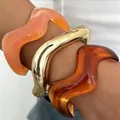 Three-piece set of wavy irregular acrylic bangles in peach, polished gold, and amber - Irregular Wave Bangle (6646105HB) / Set of 3 / Pink Gold Brown Combo