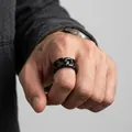 Detaillierte Nahaufnahme eines mattschwarzen Panzerkettenrings aus Titanstahl für Herren am Finger - US 5 / Schwarz