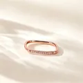 Macro-detail van een roségouden rechthoekige ring met micro-pave op een warme achtergrond - US 5 / Roségoud