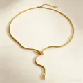 Gros plan d'un collier serpent doré en titane avec tête ornée de cristaux - Style Tête de Serpent Strass Blanc / Or