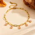 Detailed view of gold PVD titanium steel anklet with dangling pink zircon charms. - Single Anklet (O810) / Gold with Pink Zirconia
