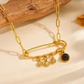 Close-up of gold safety pin pendant necklace with dangling crystal and black stone. - Safety Pin White Rhinestone Black Charm Style (A616)
