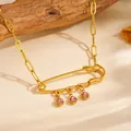 Close-up of gold safety pin necklace with pink rhinestones on textured fabric - Safety Pin Pink Rhinestone Style (A616)