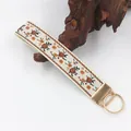 Nahaufnahme der eleganten orangefarbenen Blumenstickerei auf einem gewebten Schlüsselband - Orange Braun Kleiner Blumen (04-14A)