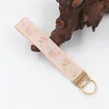 Detailansicht eines pinkfarbenen floralen Stoff-Schlüsselanhängers mit goldener Hardware. - Pink Serie Floral (04-14D)
