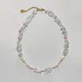 Détail d'un collier de pierres claires et perles d'eau douce avec chaîne dorée - Collier en perles avec tubes roses et pierres transparentes