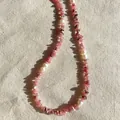Détail macro d'un collier de pierres roses irrégulières et de perles d'eau douce blanches. - Collier fait main en pierres concassées roses et perles d'eau douce