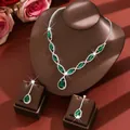 Elegant green teardrop necklace and earring set displayed on brown jewelry stands - Two-Piece Set / Green