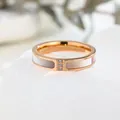 Detailed macro shot of a rose gold ring featuring triple diamonds and white shell inlay - US 5 / Rose Gold