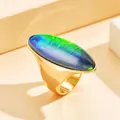 Bague vintage en métal doré avec un grand cabochon ovale aux reflets verts et bleus - Taille 7 / Coloré