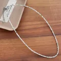 Close-up detail of 2mm natural freshwater shell bead necklace with stainless steel clasp - Green Snail Color